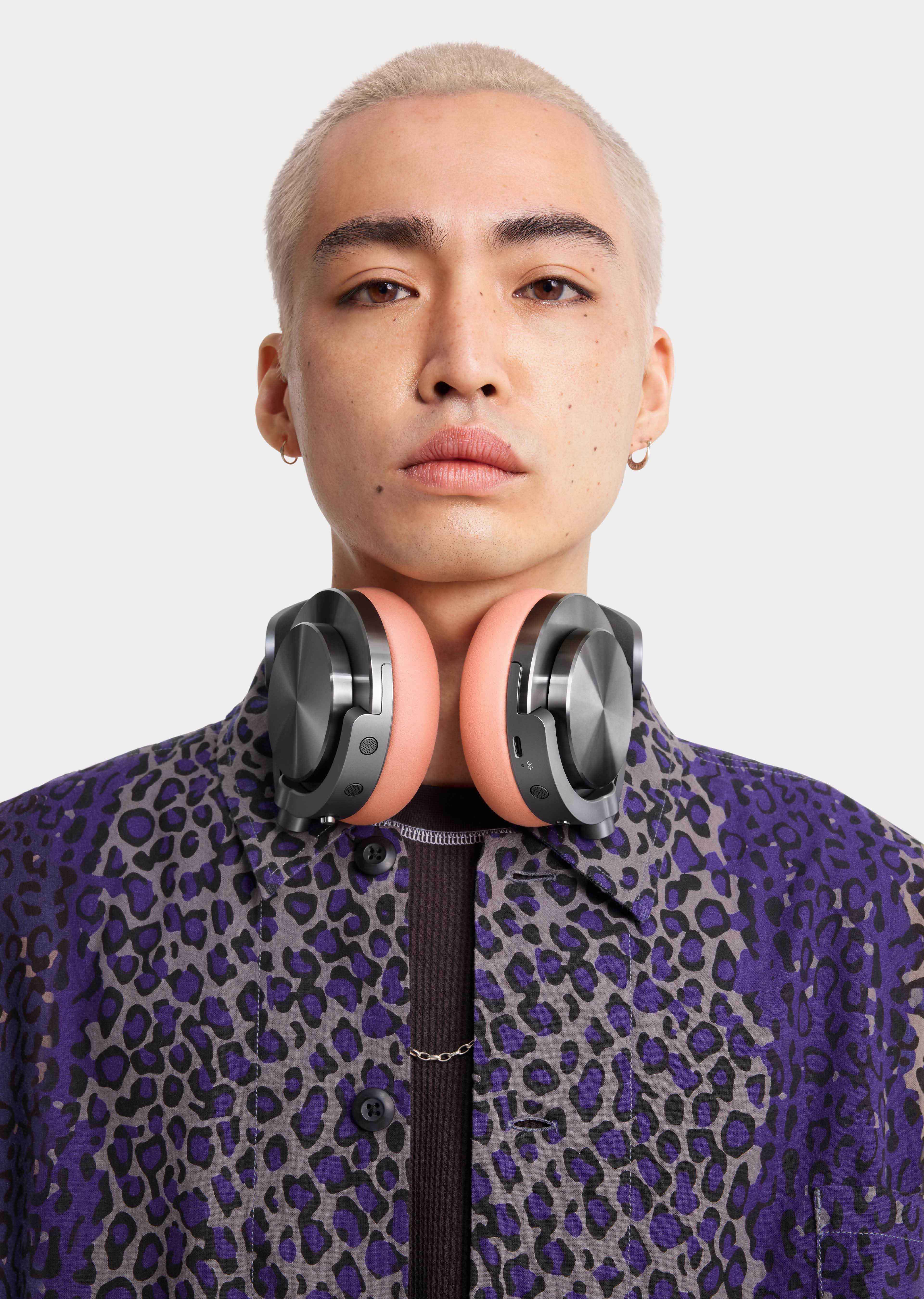 A model wearing the Dyson OnTrac headphones around their neck.
